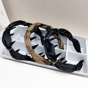Détail de serre-têtes en tissu ondulé avec cristaux et pinces antidérapantes