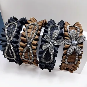 Macro view of wide pleated headbands featuring luxury rhinestones and crystal flower details