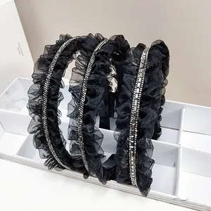 Trois élégants serre-têtes en maille noire plissée avec strass brillants sur support blanc