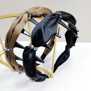 Détail de serre-têtes en satin torsadé avec cristaux et barrettes intégrées pour coiffure