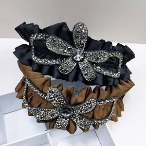 Luxe pleated satin headbands in black and brown featuring oversized rhinestone flowers