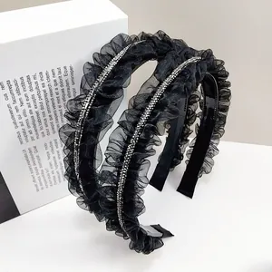 Détail de serre-têtes noirs en tulle plissé ornés de strass brillants et dentelle