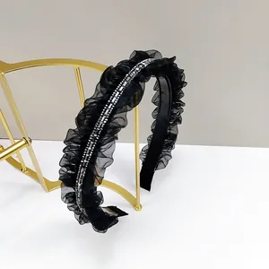 Détail d'un serre-tête noir plissé en tulle avec strass sur un support doré