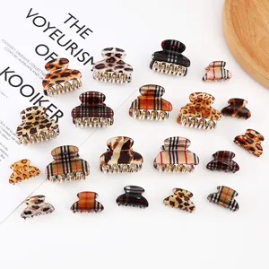 Mini leopard print and plaid hair claws set on a wooden tray with a minimalist aesthetic