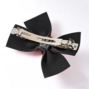 Sparkling red sequin bow hair clip with silver metal spring fastener on white background