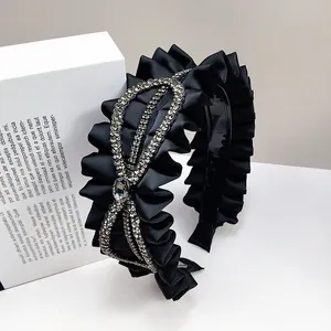 Elegant black satin pleated headband with sparkling rhinestone centerpiece accent