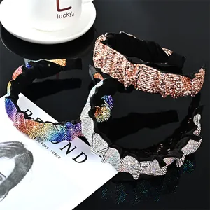 Tres elegantes diademas francesas con cristales de colores en una superficie reflectante