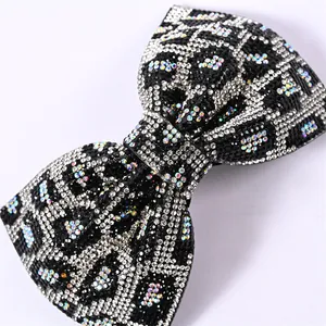 Détail macro d'une barrette nœud avec cristaux étincelants et motif léopard chic