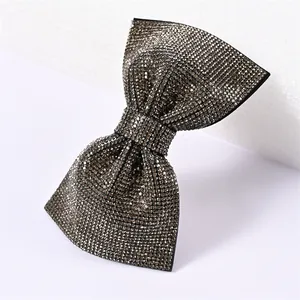 Détail d'une pince à cheveux en forme de nœud ornée de strass gris brillants et chic