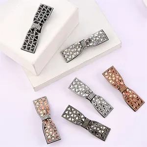 Détail macro de barrettes à nœuds en strass de différentes couleurs sur un présentoir