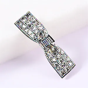 Vue détaillée d'une pince à cheveux noire ornée de strass brillants en forme de nœud