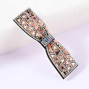 Détail de la barrette nœud avec des strass roses étincelants et gemmes polies