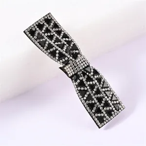 Détail macro d'une barrette nœud avec des paillettes noires et des strass brillants