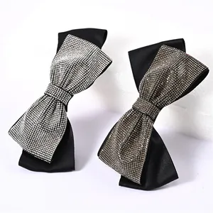 Close-up of elegant black satin bow hair clips with shimmering rhinestone embellishments