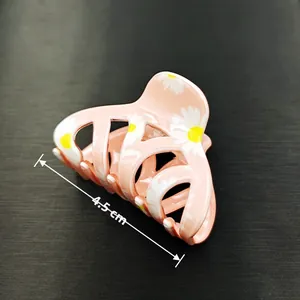 Close-up of a 4.5cm pink daisy hair claw clip with white flowers and yellow stamens