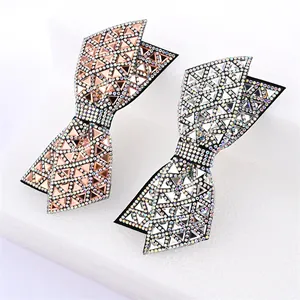 Close-up of double-layered bow hair clips with crystal rhinestones in rose gold and silver