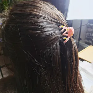 Pink matte hair claw clip with daisy floral pattern shown on dark brown hair
