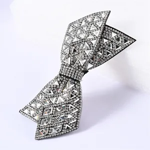 Macro detail of a black double-layered bow hair clip with crystal rhinestones and triangle stones