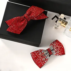 Detail view of red rhinestone bow hair clips with gradient crystals and luxury finish