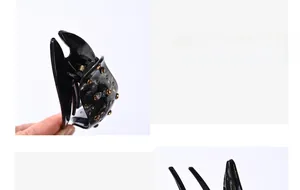 Macro detail of high-elasticity black butterfly hair clip with amber rhinestones
