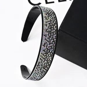 Detail of wide sparkling rhinestone headband with anti-slip inner teeth and black base
