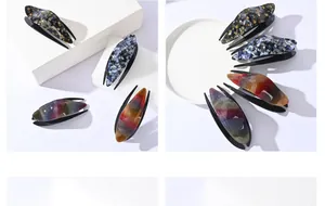 Macro detail of elegant resin duckbill hair clips with rhinestones and floral patterns