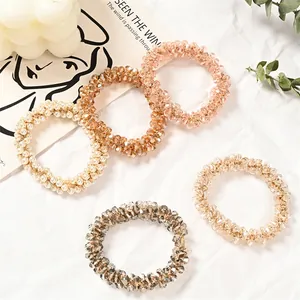Five-piece beaded hair tie set with crystals and pearls on minimalist white background
