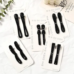 Set de 5 pinzas para el cabello con diamantes de imitación negros para mujer sobre blanco