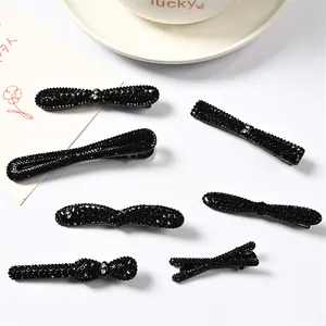 Vista detallada de varias pinzas para el cabello con diamantes negros y diseños elegantes