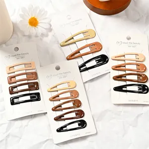 Primer plano de pinzas para el cabello de metal mate en tonos tierra en tarjeta