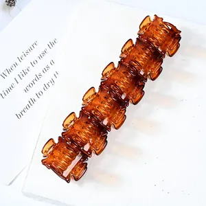 Mini amber resin hair claw clip with geometric design and glossy translucent finish