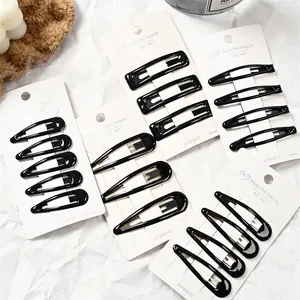 Detalle de pinzas para el cabello de metal negro brillante en forma de gota y recto