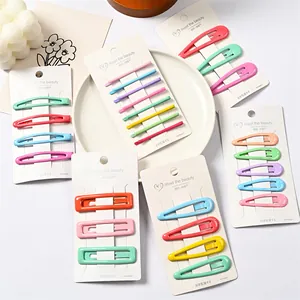 Juego de pinzas metálicas de colores sobre tarjeta blanca para niñas