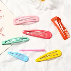 Primer plano de pinzas para el cabello de metal mate en rosa naranja verde y amarillo