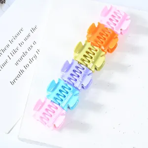 Set of six colorful mini geometric hair claws in pink, purple, and blue plastic