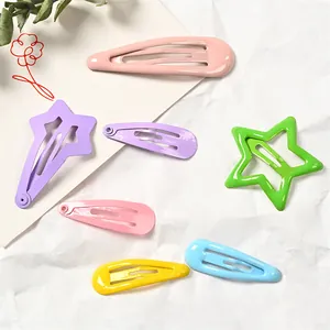 Horquillas metálicas de colores macaron con formas de estrella y gota en papel blanco