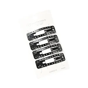 Set de 4 horquillas BB de metal negro calado con patrones geométricos en tarjeta blanca