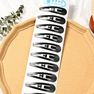 Detalle de diez pinzas para el cabello grandes en color negro mate sobre tarjeta de exhibición