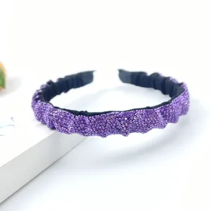 Elegant purple rhinestone bow headband with wavy pleated texture and elastic black band