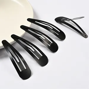 Detalle de cinco pinzas para el cabello en metal negro mate, una abierta
