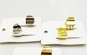 Detailopname van mini metalen haarklemmen in goud en zilver op witte kaart