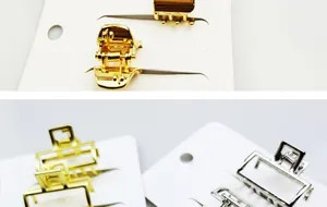 Detail van metalen mini haarklemmen in goud en zilver op presentatiekaarten