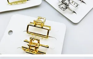 Detailweergave van geometrische gouden en zilveren haarklemmen op een kaart