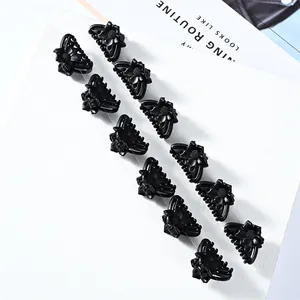 Set of 12 mini matte black flower hair claw clips displayed on a white textured board