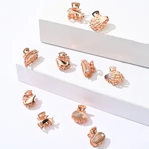 Macro detail of elegant rose gold metal hair claws in swan and feather designs