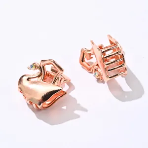 Detailed view of rose gold swan hair claw clips with colorful rhinestone accents
