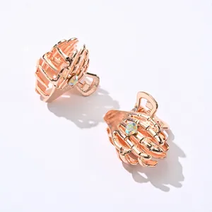 Detailed view of rose gold skeleton hand hair clips with iridescent rhinestone accents