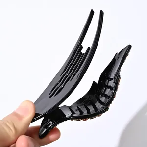 Detalle macro de la pinza para el pelo negra con brillantes ámbar y diseño antideslizante