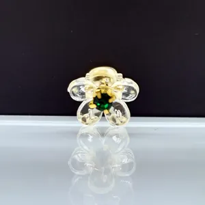 Primer plano de mini pinza de pelo de flor con pétalos claros y gema verde