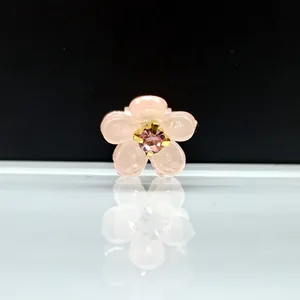 Vista macro de la pequeña pinza de flor rosa translúcida con centro de diamantes dorados